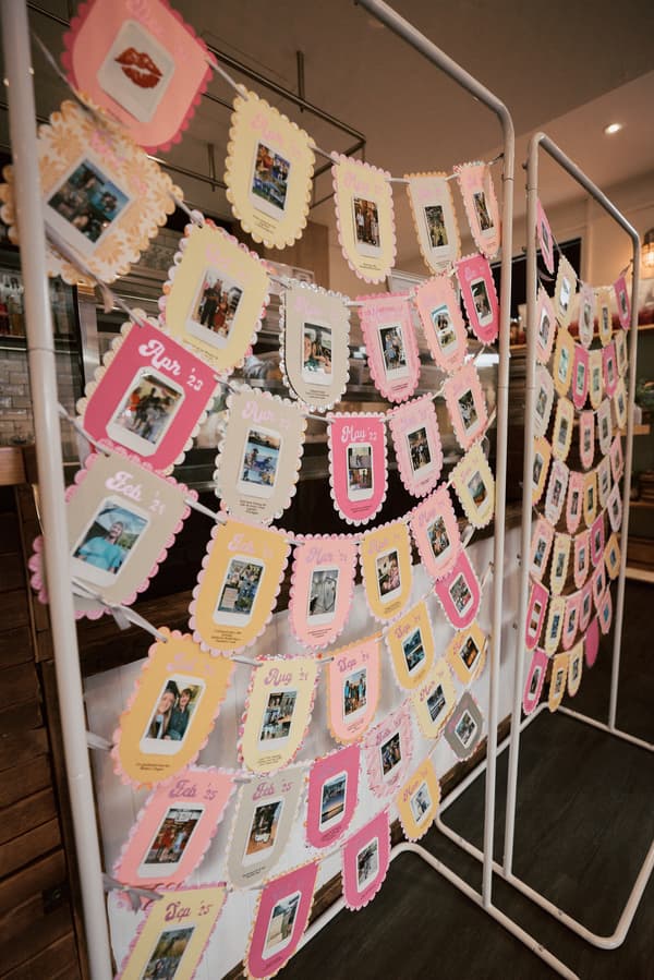 A display of colorful photo cards arranged by month and year on strings attached to white metal frames at White Horse Ranch.