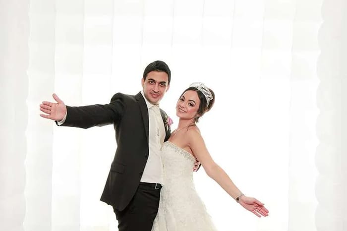 Bride and groom posing in the LED inflatable photo booth wall