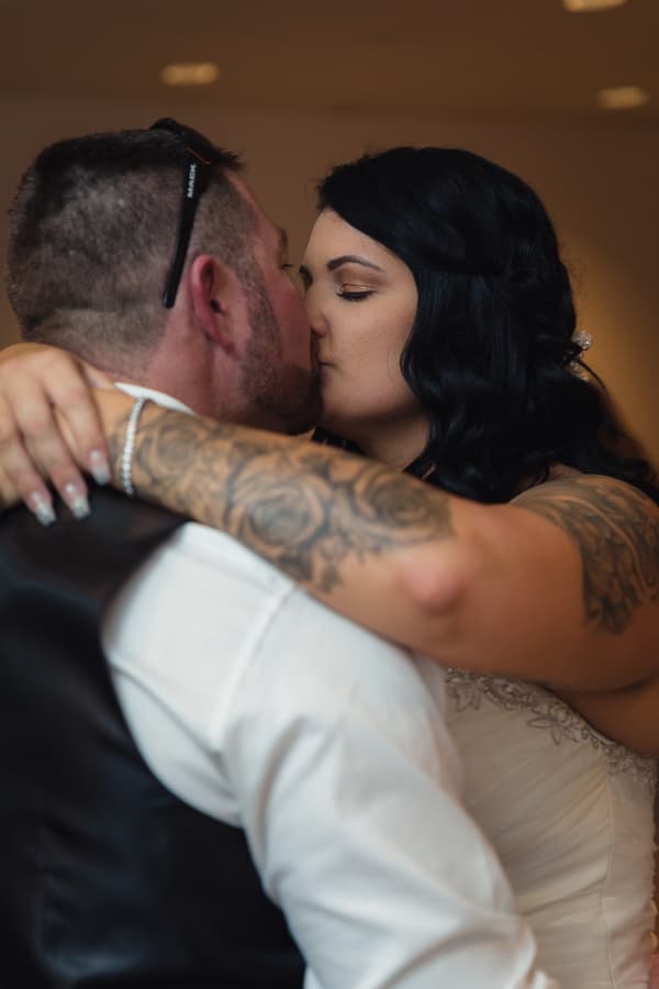 Bride Kelly and groom Shane share a close embrace and kiss during the reception at Novotel Sunshine Coast Resort.