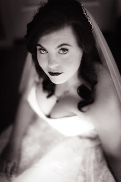 The bride Holly in her wedding dress looking up at the camera in a close-up portrait. Cinematic photography wedding by She Said Yes.