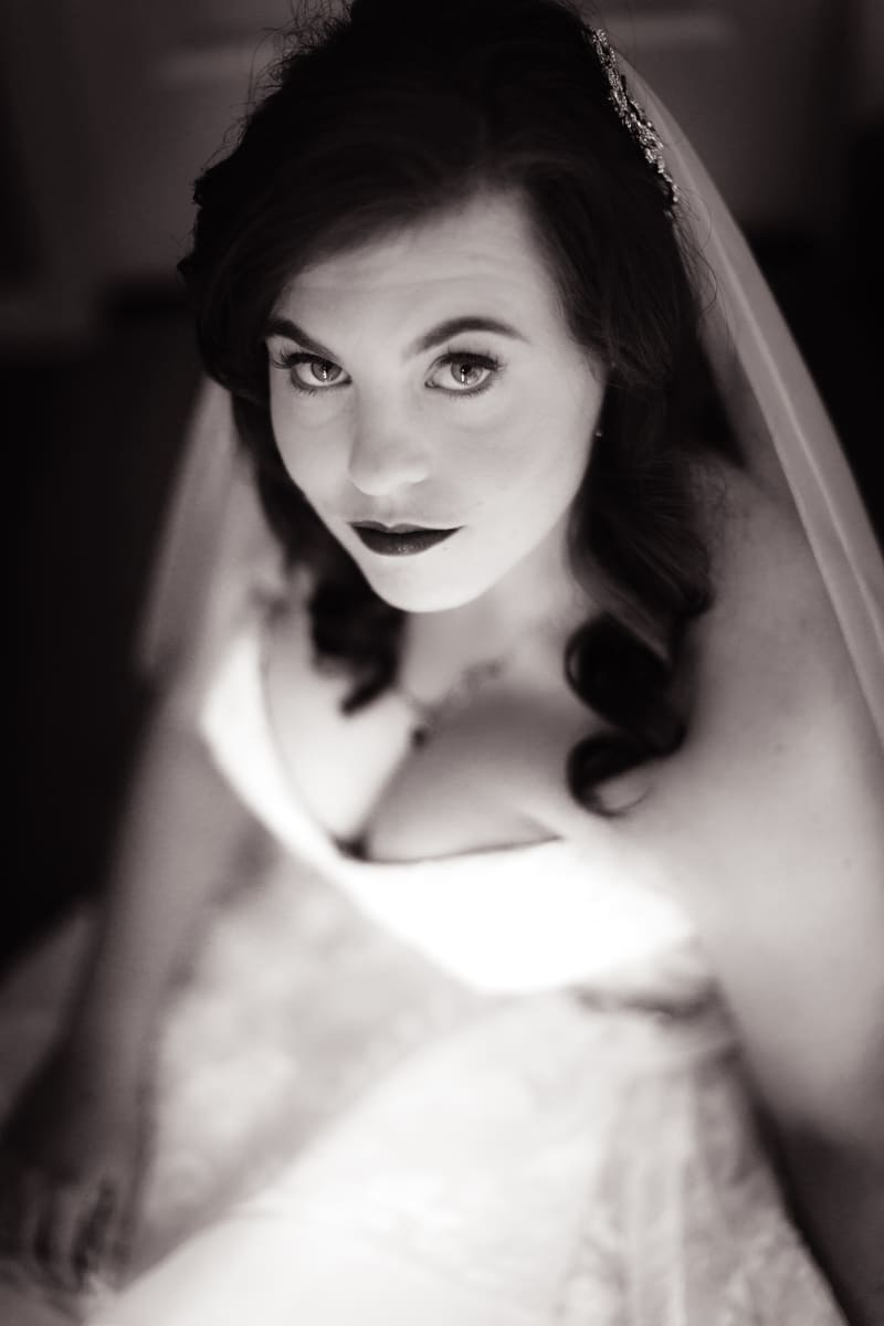 The bride Holly in her wedding dress looking up at the camera in a close-up portrait. Engagment party by She Said Yes.