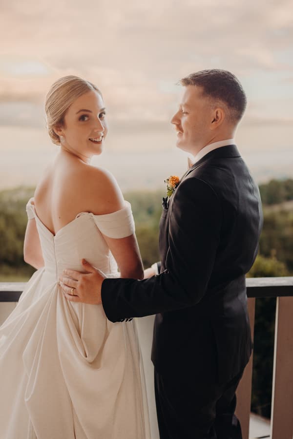 Courtney and Liam pose for couple portraits at Tiffany's Maleny with a scenic outdoor background.
