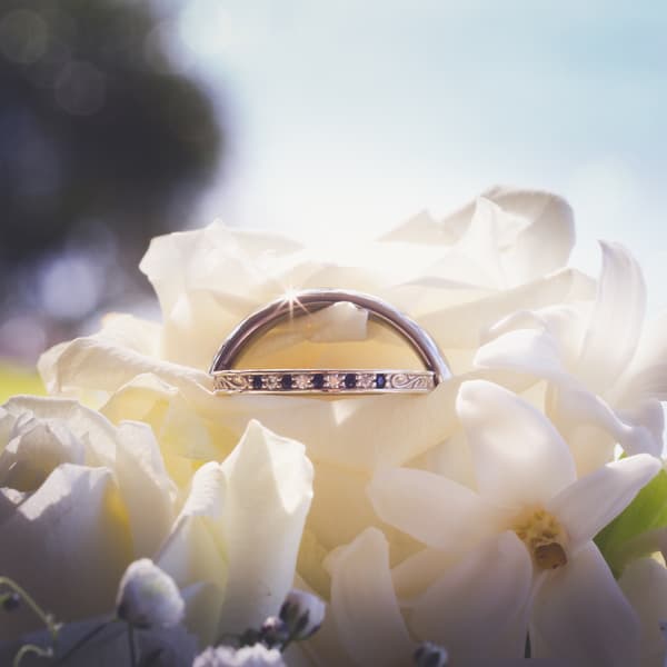 Close-up of a wedding ring resting on white flowers at the Toowong Rowing Club — The Malouf Room.
