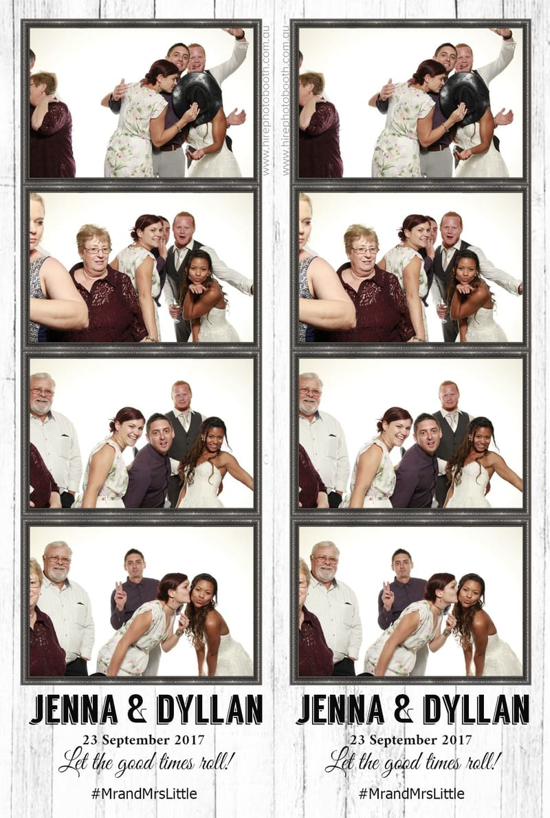 Group of guests posing playfully in a photo booth with props.
