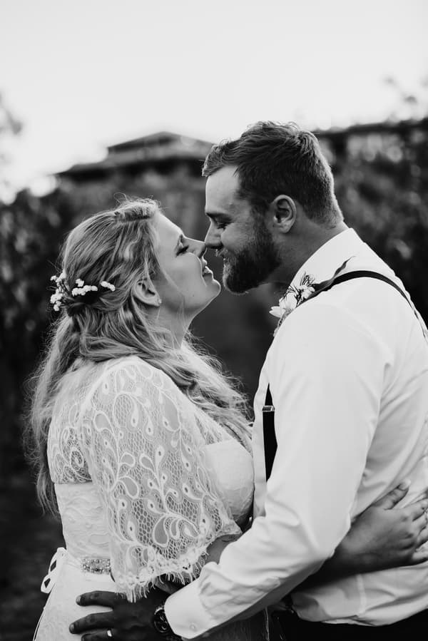 The bride Annie and groom Trent embrace closely, about to touch noses, at Ocean View Estates during their couple portraits session.