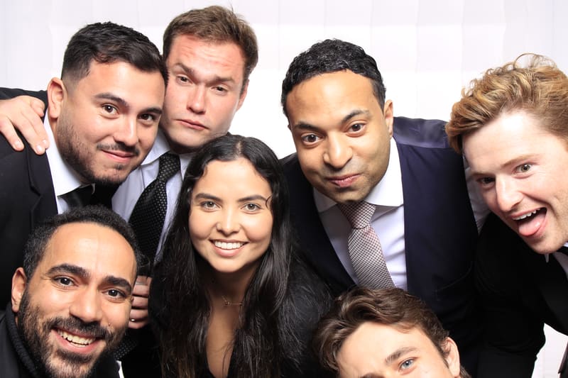 Group of smiling guests posing together in a photo booth.