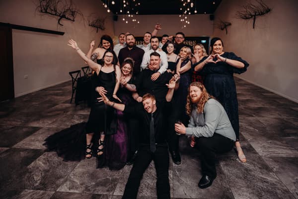 Wedding party members pose together for a group photo in the Ocean View Estates Function Room during the reception stage.