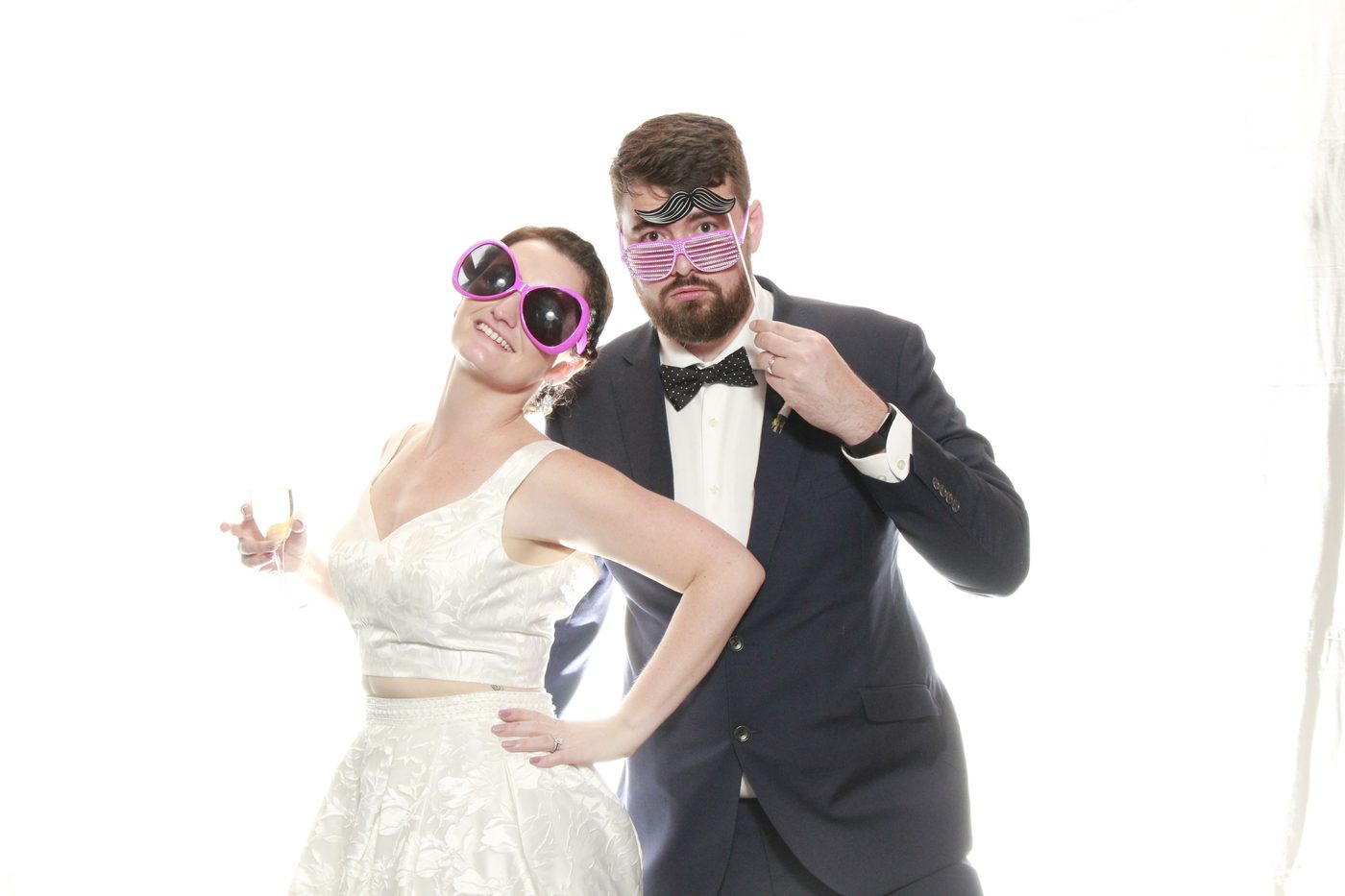 Couple posing with oversized sunglasses and playful expressions.
