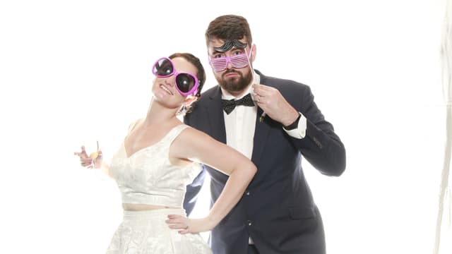 Couple posing with oversized sunglasses and playful expressions.