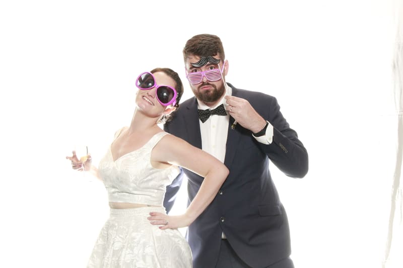 Couple posing with oversized sunglasses and playful expressions.