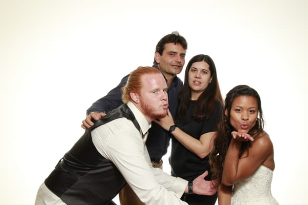Group of four posing playfully in a photo booth.