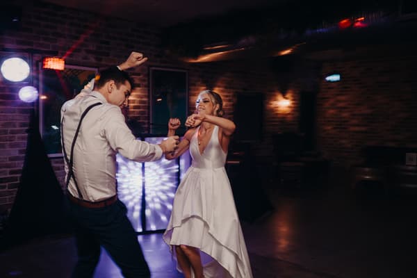 Courtney the bride and Cameron the groom dance together at the reception stage in Sandstone Point Hotel — Cellar.