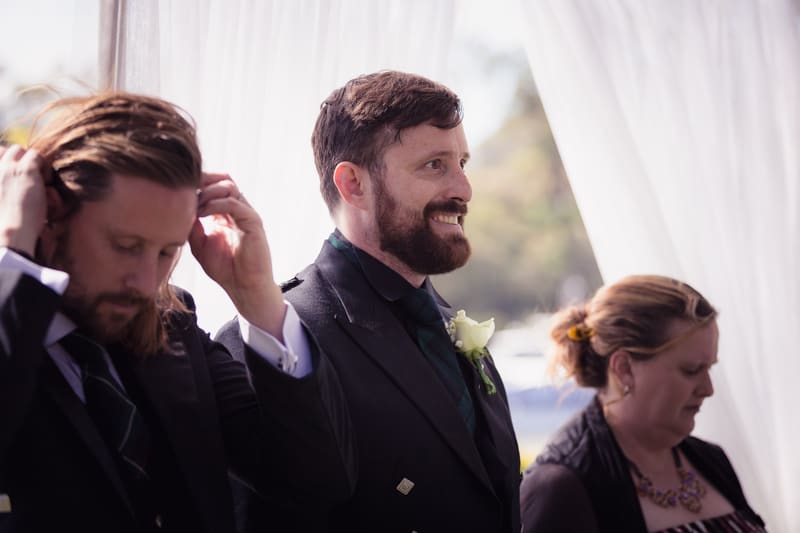 The groom and two guests stand near white draped fabric at the. Elopement photography Brisbane by She Said Yes.
