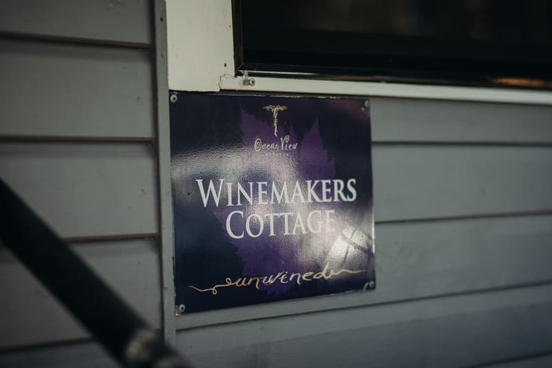 Sign on a wall reading 'Ocean View WINEMAKERS COTTAGE unwined' at Ocean View Estates.