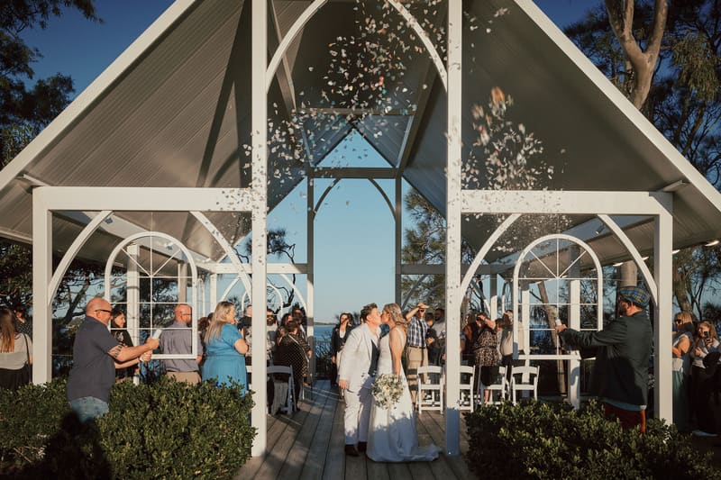 Brides Mandy and Selina kiss at the. Engagement celebration by She Said Yes.