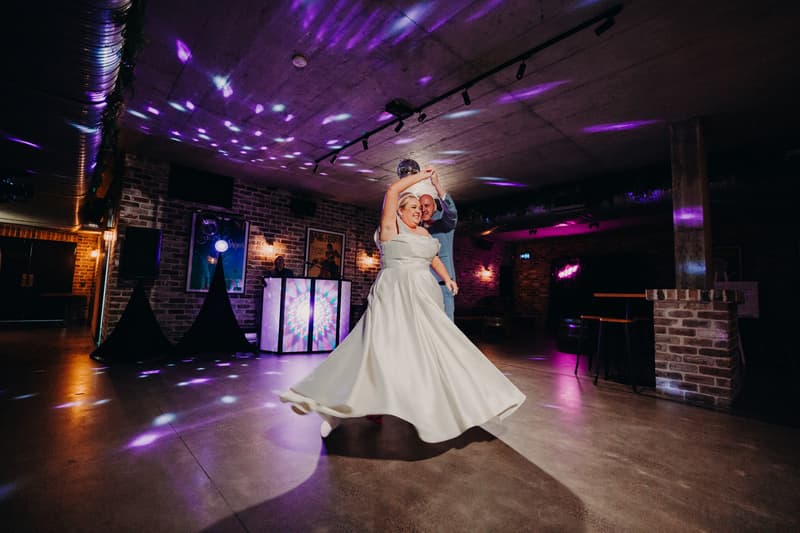 The bride Jacquelyne and groom Arran dance together on the dance floor at Sandstone Point Hotel — Cellar during the wedding reception.
