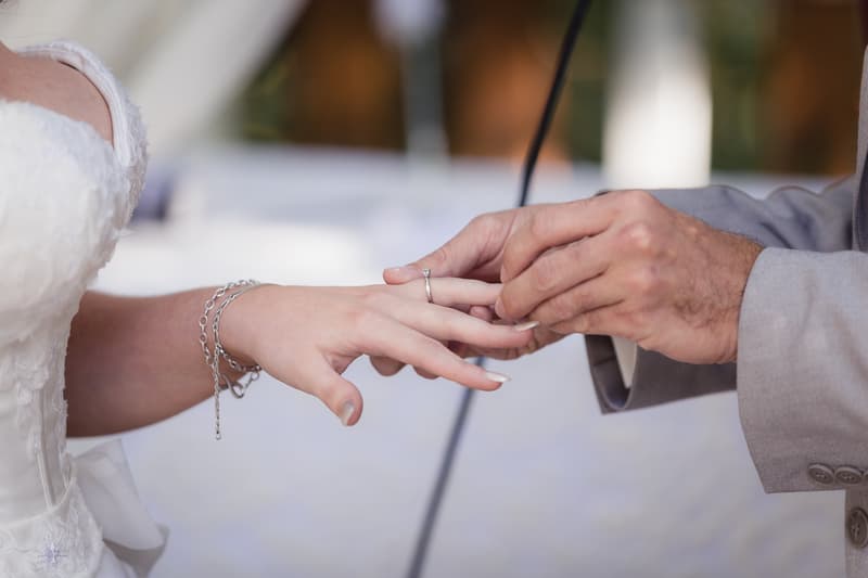 Paul places a wedding ring on Holly's finger during the ceremony at Kwila Lodge.