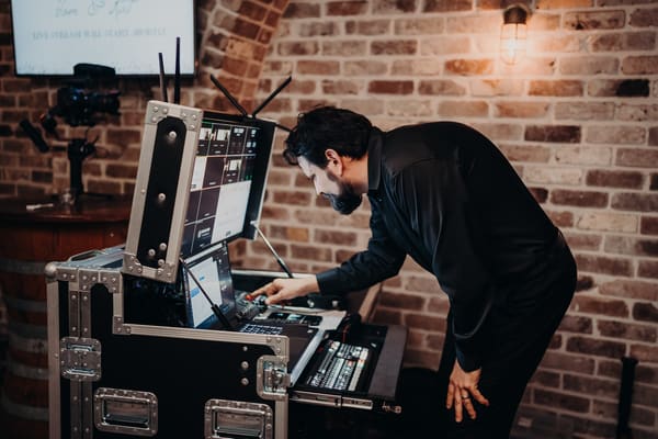 Wide shot of Roman setting up a wedding live-streaming broadcast station