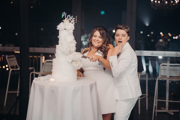 Brides Brooke and Tiffany cut their wedding cake together at the reception in the Pumicestone Room at Sandstone Point Hotel.