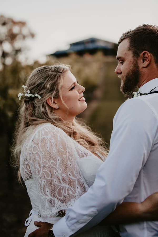 The bride Annie and groom Trent embrace and look at each other during their couple portraits session at Ocean View Estates.