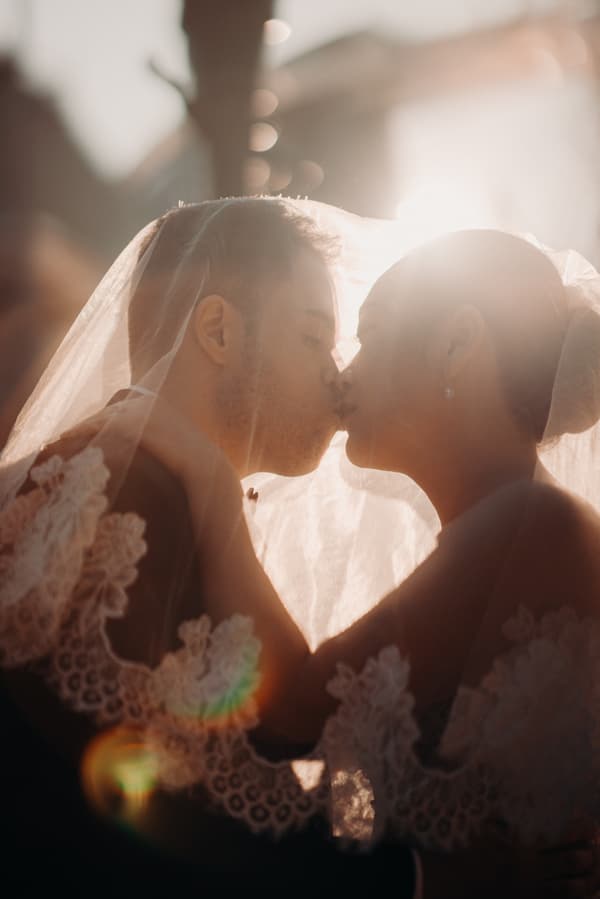 Bride Aria and groom Antony share a kiss under the bride's lace veil at Queensland Parliament building during their couple portraits session.