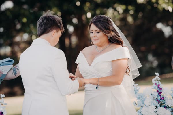 Brooke and Tiffany exchange rings during their wedding ceremony at Sandstone Point Hotel — The Pavilion.