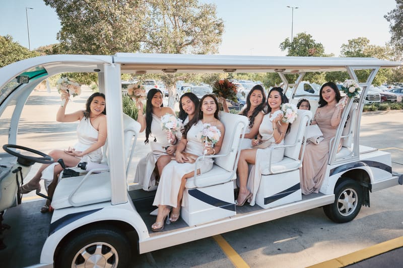 Bridesmaids sit in a white open-sided vehicle holding bouquets. Elopement photography Brisbane by She Said Yes.