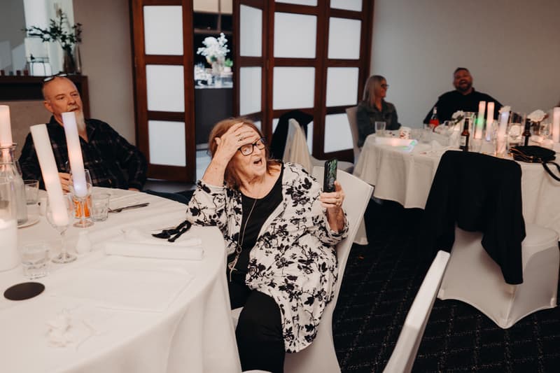 Older guests seated at round tables with white tablecloths in The Tides — The Pandanus Room during the wedding reception.