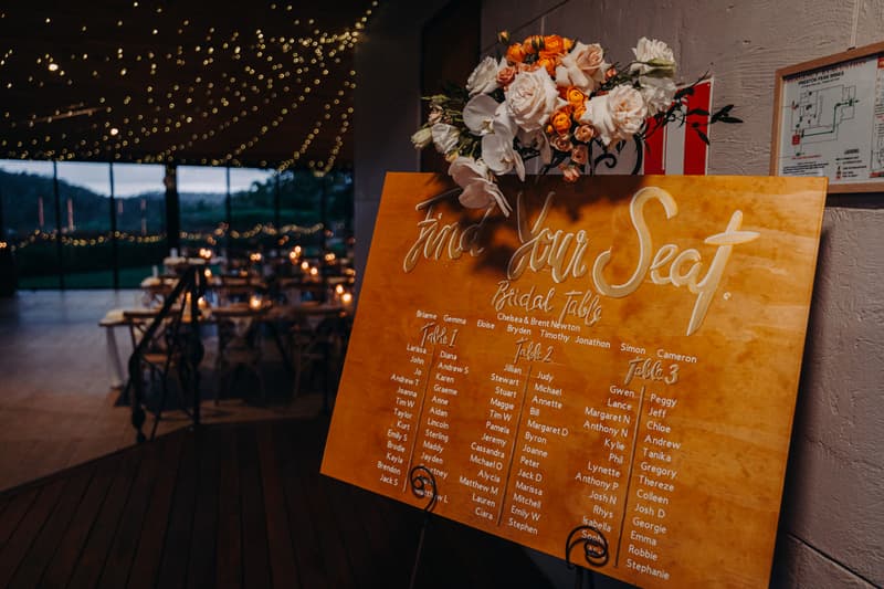 Seating chart board with floral arrangement at Preston Peak Winery Functions Centre showing table assignments for Chelsea and Brent's wedding reception.