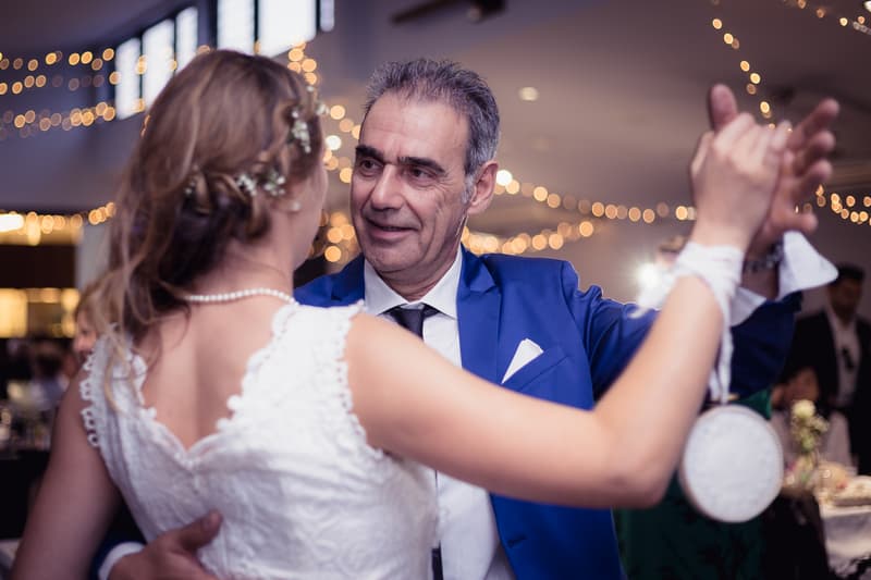 The bride Francesca dances with an older man, likely her father, at the reception in The Malouf Room at Toowong Rowing Club.