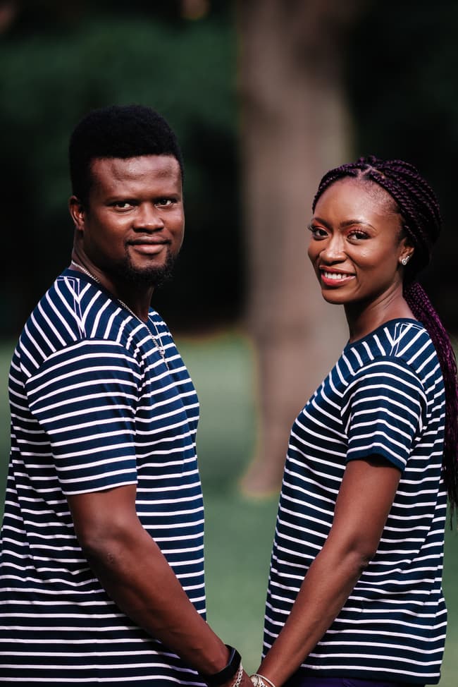 The couple holds hands and smiles warmly at the camera, standing side by side in Brisbane's City Botanic Gardens.