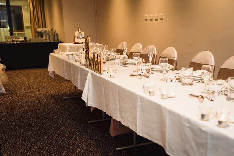 Reception table set with white tablecloth, glassware, candles, and a decorative 'Mr & Mrs' sign at Novotel Sunshine Coast Resort.