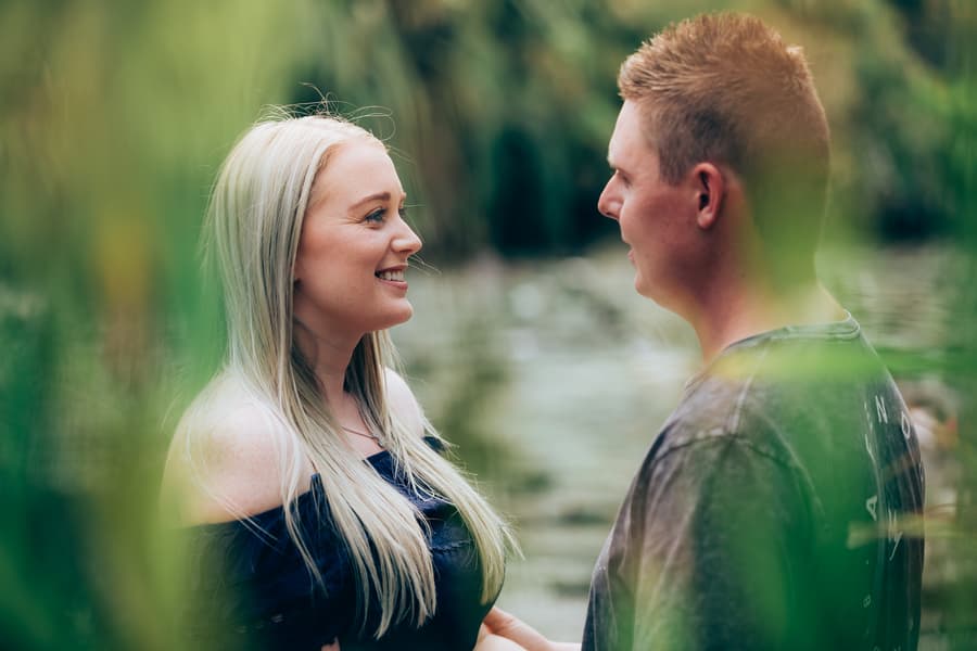 The couple smiling at each other, surrounded by greenery at City Botanic Gardens.