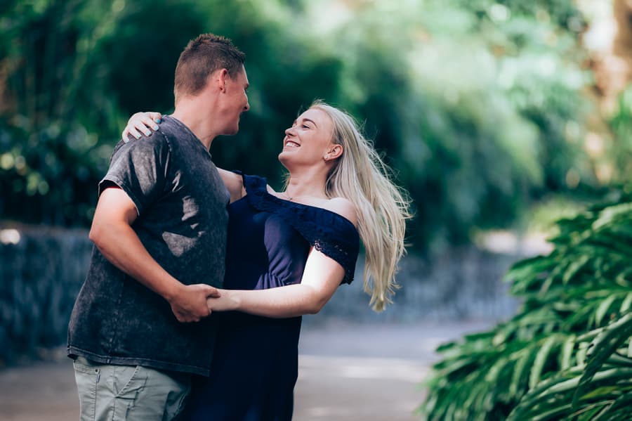 The couple dancing playfully on a path, surrounded by greenery at City Botanic Gardens.