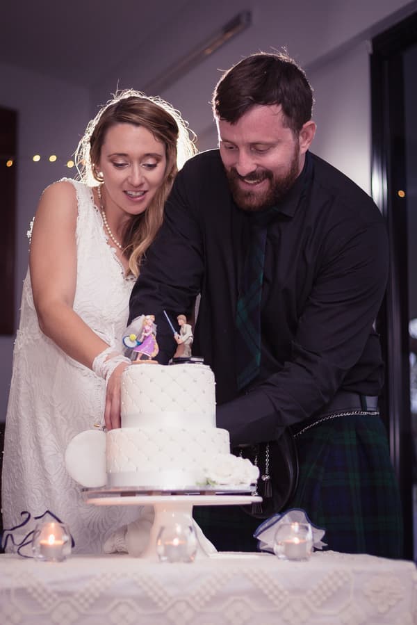 Francesca the bride and Ben the groom cut their wedding cake together at the reception in The Malouf Room, Toowong Rowing Club.