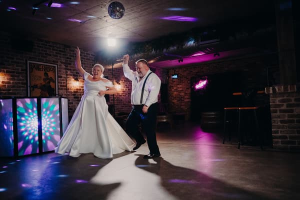 Bride Jacquelyne and groom Arran dance together on the floor at Sandstone Point Hotel — Cellar during the wedding reception.