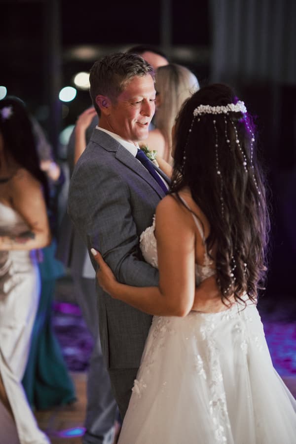 Bride Jheng and groom Dane dance together at the reception in The Pumicestone Room at Sandstone Point Hotel.