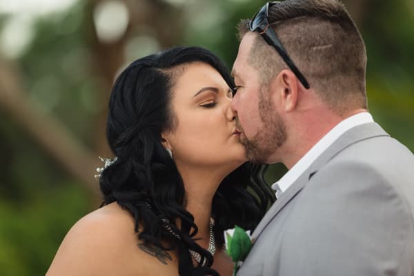 The bride Kelly and groom Shane share a kiss during their ceremony at Novotel Sunshine Coast Resort.