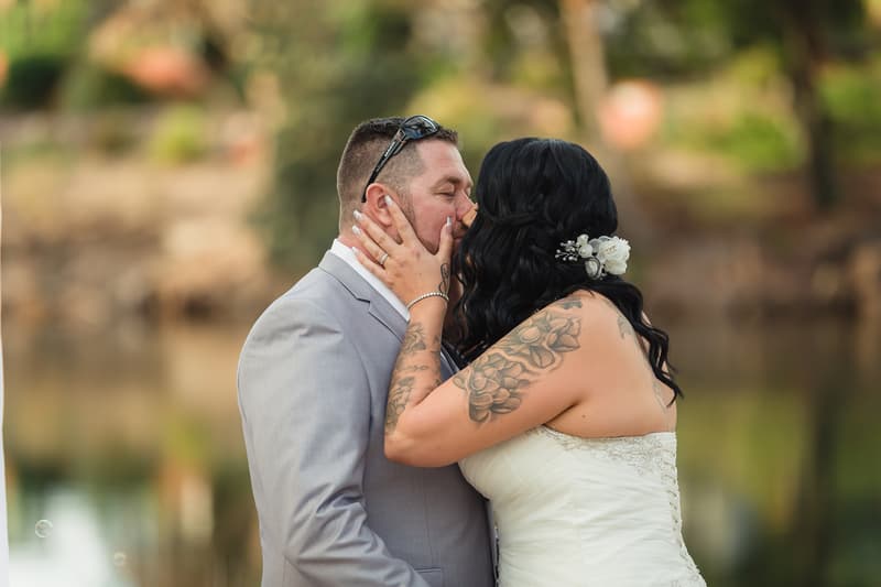 The bride Kelly and groom Shane share a kiss outdoors at Novotel Sunshine Coast Resort during their wedding ceremony.
