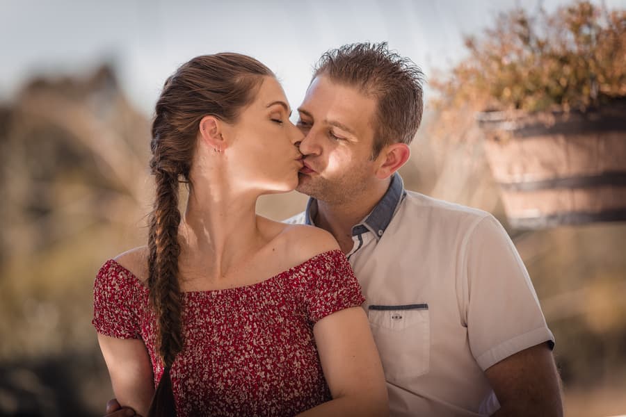 The couple sharing a kiss, sitting closely together with soft light at The Abbey Cobaki.