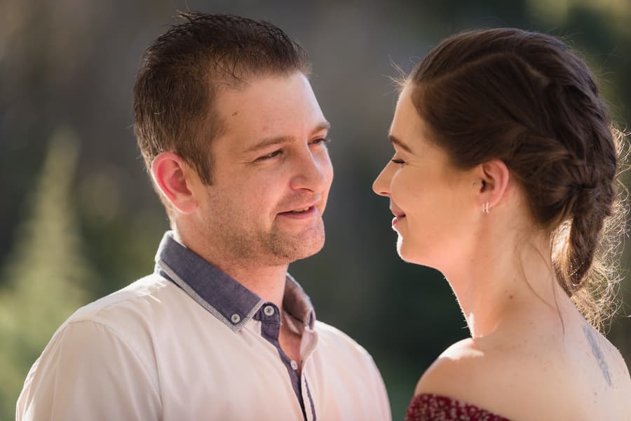 The couple gazing into each other's eyes with soft expressions, surrounded by greenery at The Abbey Cobaki.