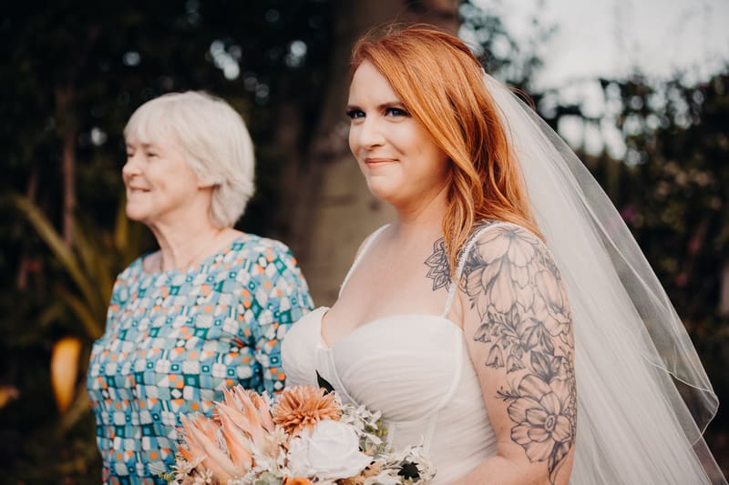 The bride Lilas stands outdoors, accompanied by an older woman who is likely the mother of the bride. Brisbane wedding photographers by She Said Yes.