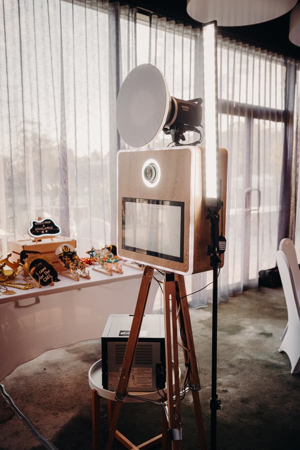 Photo booth setup with lighting equipment and props table at Eatons Hill Hotel — Hills Room.