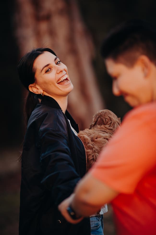 One person laughs joyfully while holding a dog, as the other leads them by the hand at Hillstone St Lucia.