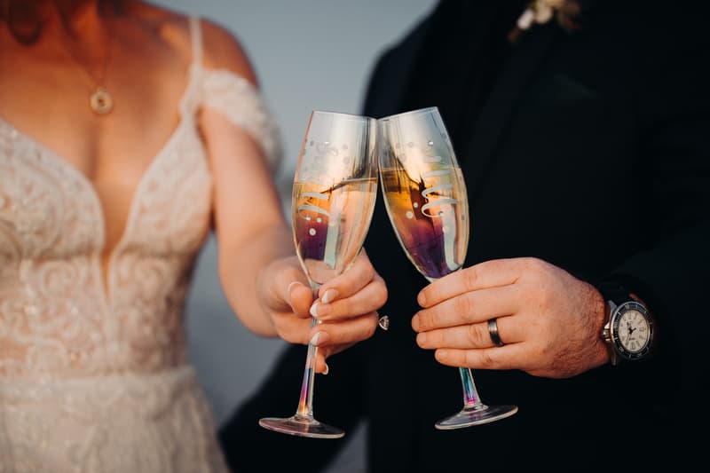 The bride and groom at Sandstone Point Hotel toast with champagne flutes during their couple portraits session.