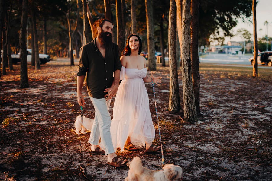The couple walks with their dogs at Woorim Beach, the man looking at the woman with affection.