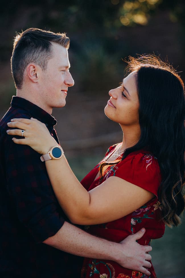 The couple embraces closely, gazing into each other's eyes with soft smiles.