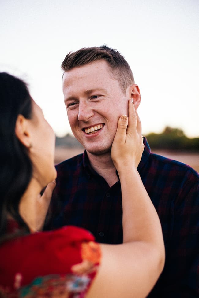 Close-up of the couple smiling at each other, with the woman touching the man's face affectionately.