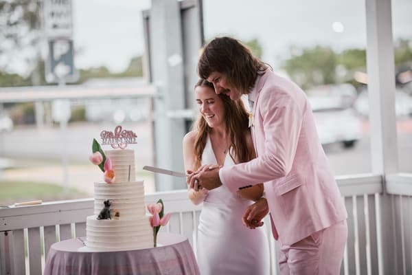 Olivia the bride and Jake the groom cut their wedding cake together on the reception stage at White Horse Ranch.