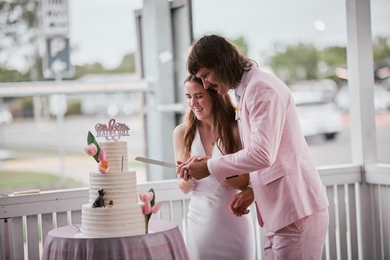 Olivia the bride and Jake the groom cut their wedding cake together on the reception stage at White Horse Ranch.